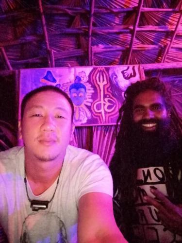 two men sitting in a room with purple lights at Freedom camp & cafe ella in Ella