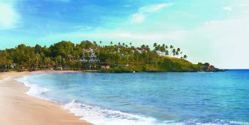 an island with trees and houses on a beach at The Leela Kovalam, A Raviz Hotel in Kovalam