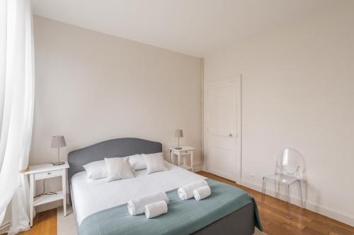 a bedroom with a bed with two towels on it at LE SEIZE - Appartement spacieux au cœur d'un quartier calme de Rennes in Rennes
