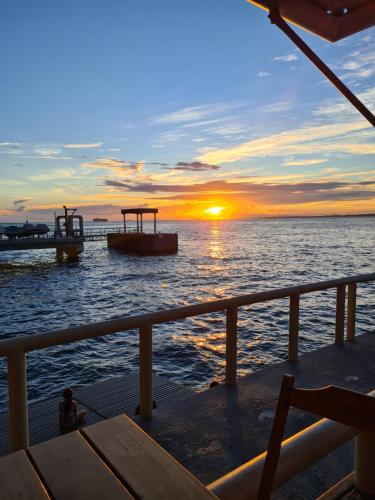 a person sitting on a boat watching the sunset at Flat Sol Victoria Marina Vista Mar in Salvador