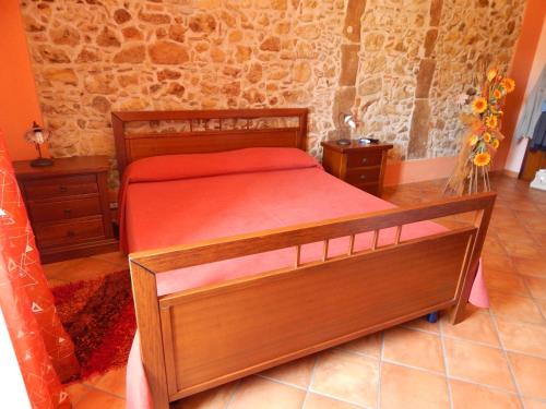 a bedroom with a wooden bed with a red blanket at B&B Del Borgo in San Marco Argentano