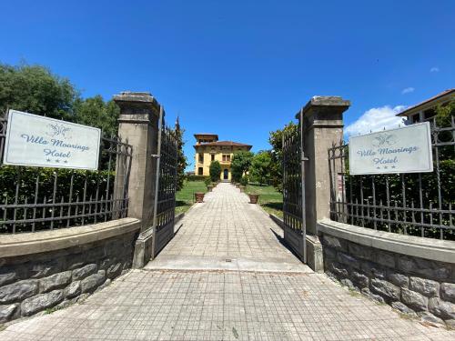 a gate to a house with a building in the background at Villa Moorings in Barga