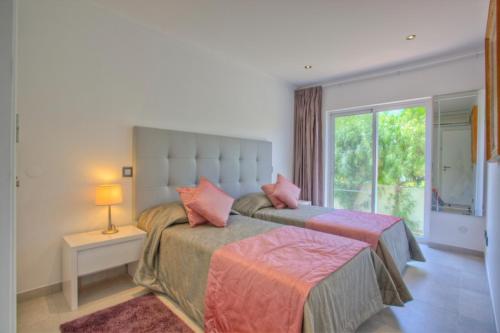 a bedroom with a large bed with pink pillows at Casa da Horta in Almancil