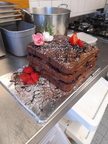 a chocolate cake with strawberries on top of a counter at Les Roches Chambre d'Hotes in Servant