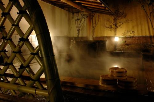 a room with a stove with smoke in it at Kamiyamada Hotel in Chikuma