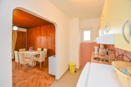eine Küche und ein Esszimmer mit einem Tisch und Stühlen in der Unterkunft Apartments Dandelion in Biograd na Moru