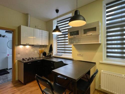 a kitchen with a table and chairs in a room at River Apartment Riga in Rīga
