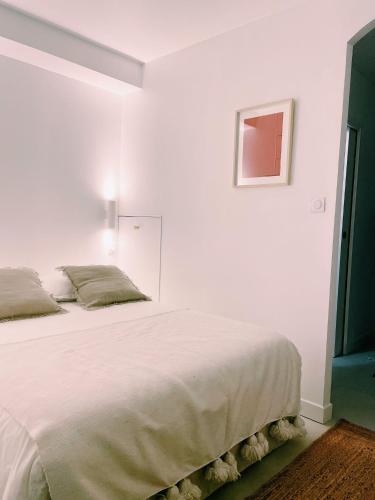 une chambre avec un grand lit blanc dans une pièce dans l'établissement Studio d'architecte à 150 m de la plage, à Royan