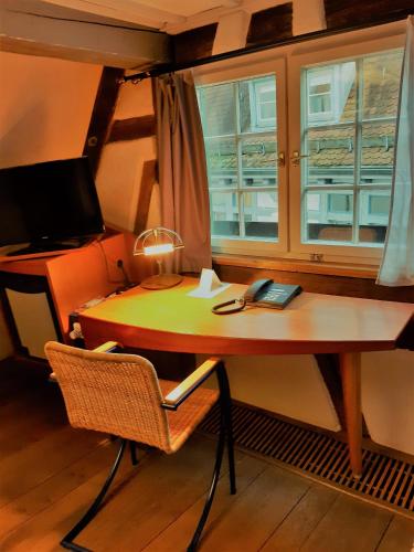 a desk with a chair next to a window at Schiefes Haus in Ulm