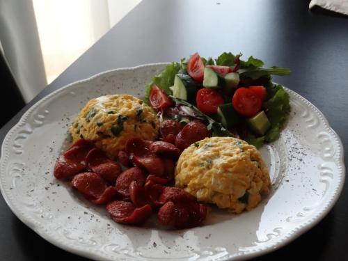 a plate of food with strawberries and a salad at Hotel Keto in Podgorica