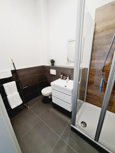 y baño con ducha, aseo y lavamanos. en Best Boarding House, en Hanau am Main