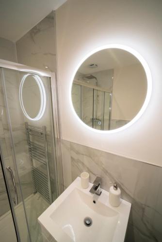 a white bathroom with a sink and a mirror at Foundry Farm Cottage in Hexham