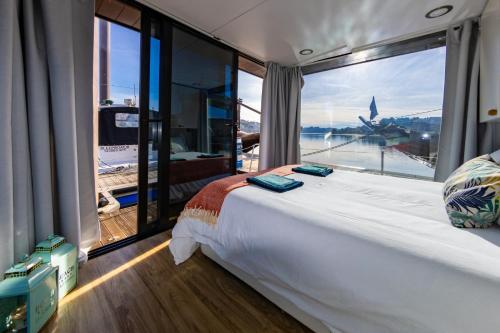 duże łóżko w pokoju z dużym oknem w obiekcie Oporto Douro Floating House w Porto