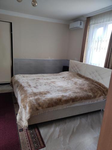 a bedroom with a large bed with a blanket at Guest House Koba in Batumi