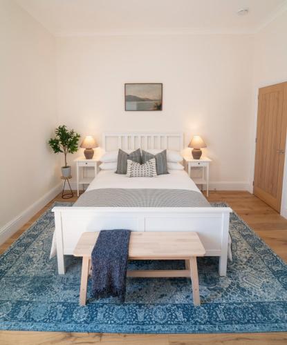 a bedroom with a large bed and a blue rug at Foundry Farm Apartment in Hexham
