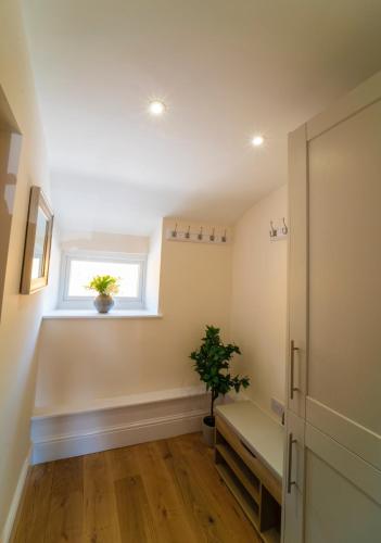 a room with a bench and a window and a plant at Foundry Farm Apartment in Hexham