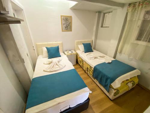 two beds in a small room with blue pillows at CityHub in Antalya