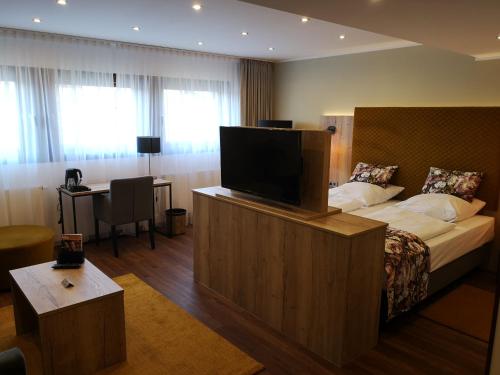 a hotel room with a bed and a flat screen tv at Hotel Spahr in Stuttgart