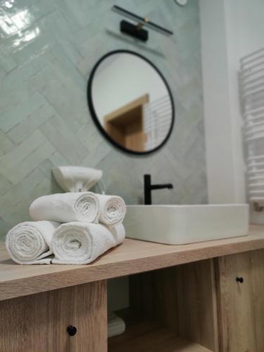 a bathroom with a sink and a pile of towels at 4 Kąty Apartamenty Koronowo in Koronowo