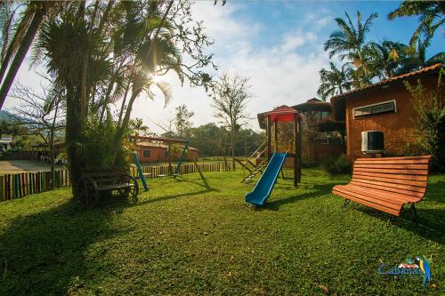 a playground with a slide and a swing set at Cabanas Termas Hotel in Gravatal