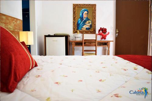 a bedroom with a bed and a painting on the wall at Cabanas Termas Hotel in Gravatal