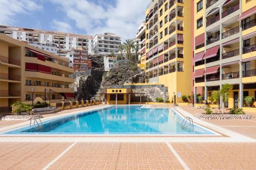 basen przed kilkoma budynkami mieszkalnymi w obiekcie OLIVIA SUNSET Perfect Stay by Sunkeyrents w mieście Puerto de Santiago