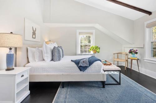Dormitorio blanco con cama y alfombra azul en Lambert's Cove Inn & Resort, en West Tisbury