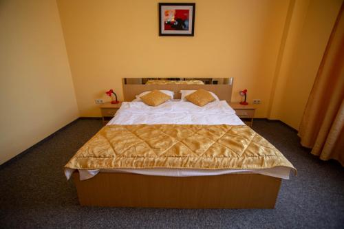 a bedroom with a large bed and two tables at Hotel Alexandra in Timişoara