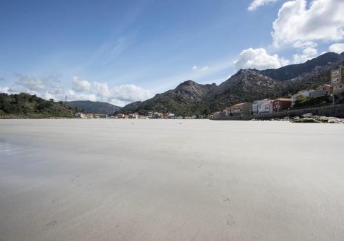 a view of a beach with mountains in the background at Apartamento Chamela in O Pindo
