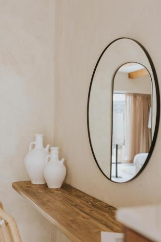 a bathroom with a mirror and vases on a shelf at Hotel Anilevich Mansion in Beer Sheva