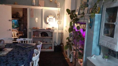 a living room with a table and chairs and a fireplace at Marjune Guest House in Weymouth
