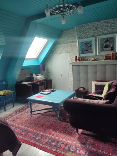 a living room with a blue table and a couch at Appart'hotel Maison Saint Michel in Paimpol