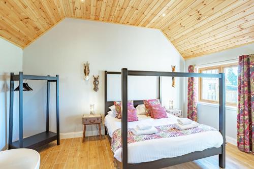 a bedroom with a bed and a wooden ceiling at Kestrel Lodge 6 with Hot Tub in Newton Stewart