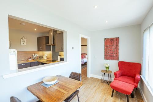 a living room with a red chair and a table at Kestrel Lodge 6 with Hot Tub in Newton Stewart