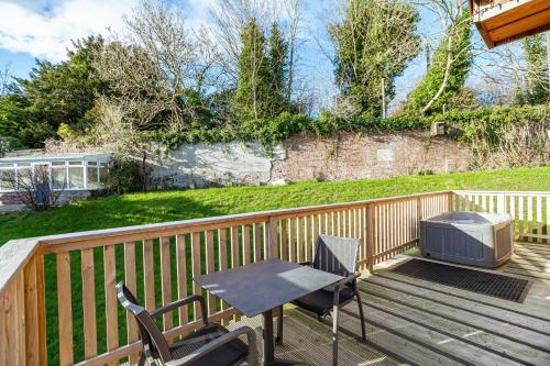 a patio with a table and a television on a deck at Kestrel Lodge 6 with Hot Tub in Newton Stewart