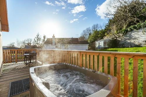 a hot tub on the deck of a house at Kestrel Lodge 6 with Hot Tub in Newton Stewart