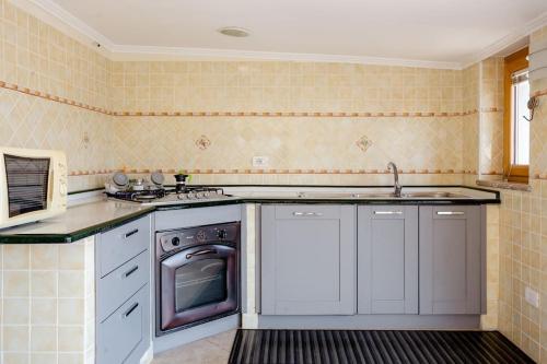 a kitchen with a sink and a dishwasher at Kalaskiso' in Giardini Naxos