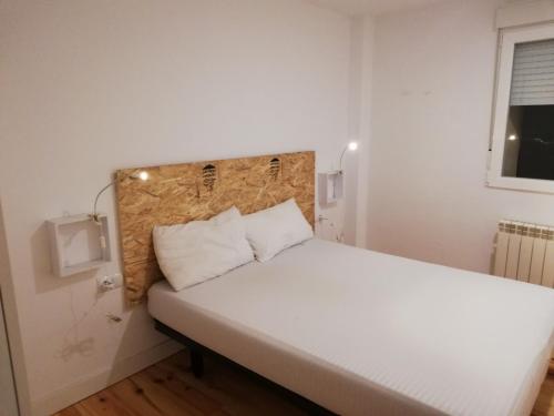 1 dormitorio con 1 cama grande con sábanas blancas en Calle Carmen Céntrico Amplio, en Pamplona