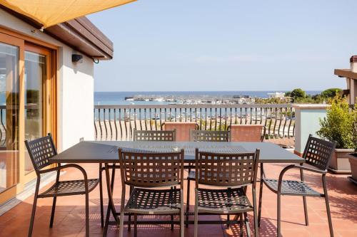 - une table et des chaises sur une terrasse avec vue sur l'océan dans l'établissement Kalaskiso', à Giardini Naxos