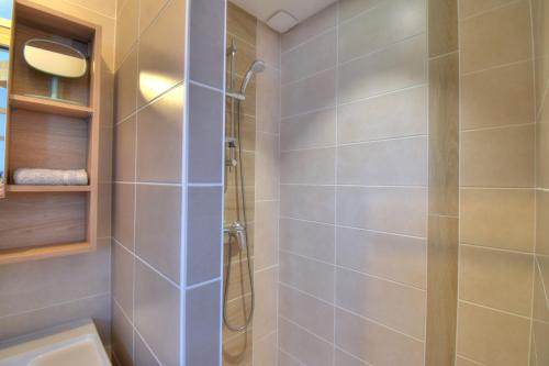 une salle de bain avec une douche avec une porte vitrée dans l'établissement La vie en rose, à Ploubezre