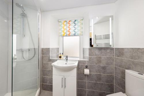 a bathroom with a sink and a toilet and a shower at The Gables Guest House in Ambleside