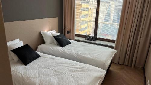 two beds in a hotel room with a window at Apartament Ogrodowa Deluxe in Warsaw