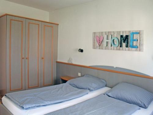 um quarto com duas camas e uma placa que lê casa em Ferienhaus Nr 14, Kategorie Komfort, Feriendorf Hochbergle, Allgäu em Bichel