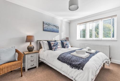 a bedroom with a bed and a chair and a window at Kittiwake in Highcliffe