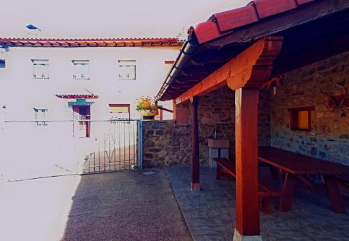 a patio with a wooden bench next to a building at Casa Rural Burón in Posada de Valdeón
