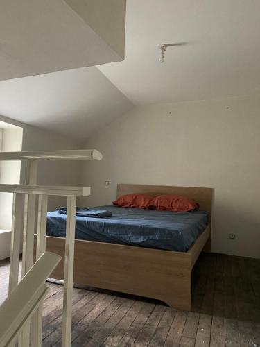 a bedroom with a bed with blue sheets and red pillows at Appartement calme centre ville historique in Ussel