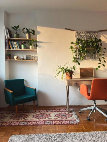 a room with two chairs and a desk with plants at Vándor Apartman in Veszprém