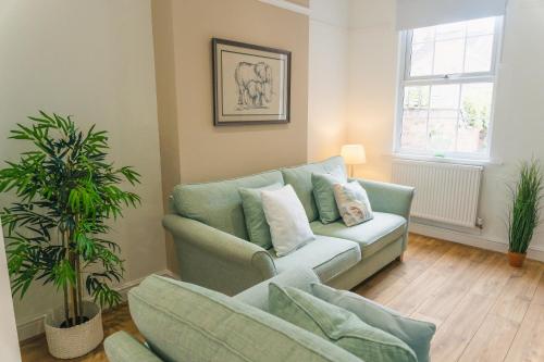 a living room with a couch and a plant at Villiers House - Comfy Stylish Home in Leamington Spa