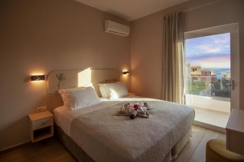 two stuffed animals sitting on a bed with a window at Vakakis Family Luxury Studios in Palaiochóra