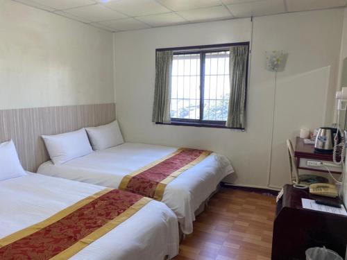 a hotel room with two beds and a window at Song Mao Homestay in Leye